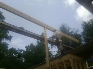 Carpenter setting a ridge beam over a new addition frame — Ice Dam Removal by Roofing Brothers in Bovill