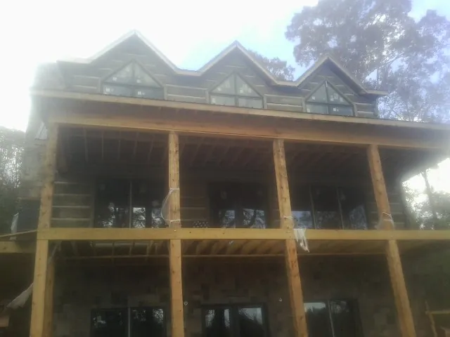 Dormers and porch framing on a large log home under construction — Roof Coating work by our crew in Bovill