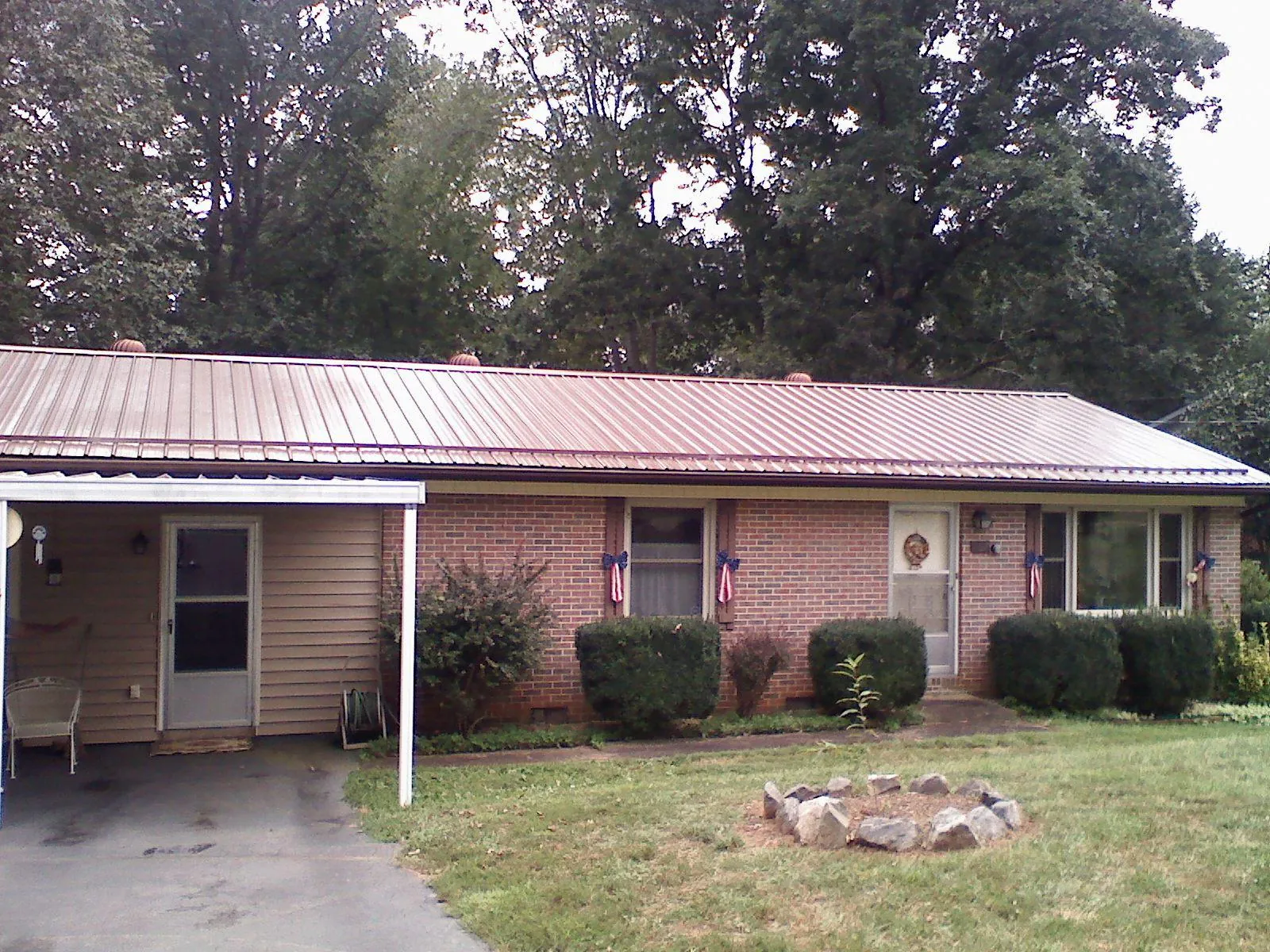 Bronze metal roof and carport on a brick ranch home — Roof Repair work by our crew in Bovill
